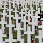 
              FILE - A young woman visits headstones of World War II soldiers prior to a ceremony to mark the 75th anniversary of D-Day at the Normandy American Cemetery in Colleville-sur-Mer, Normandy, France, on June 6, 2019. World leaders gathered in France to mark the 75th anniversary of the D-Day invasion that helped liberate Europe from Nazi Germany. Emmanuel Macron and President Donald Trump praised the soldiers, sailors and airmen who took part in the invasion, codenamed Operation Overlord, saying it was the turning point that ended Nazi tyranny and ensured peace for Europe. French President Emmanuel Macron has formally announced that he will seek a second term in April’s presidential election. (AP Photo/David Vincent, File)
            
