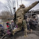 
              People cross the Irpin river on an improvised path under a bridge that was destroyed by a Russian airstrike, while fleeing the town of Irpin, Ukraine, Saturday, March 5, 2022. What looked like a breakthrough cease-fire to evacuate residents from two cities in Ukraine quickly fell apart Saturday as Ukrainian officials said shelling had halted the work to remove civilians hours after Russia announced the deal. (AP Photo/Vadim Ghirda)
            