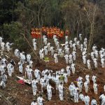
              In this photo released by Xinhua News Agency, search and rescue workers pause for a three-minute moment of silence for the 132 people killed at the China Eastern flight crash site in Tengxian County on Sunday, March 27, 2022, in southern China's Guangxi Zhuang Autonomous Region. The second "black box" from a China Eastern Boeing 737-800 was found Sunday, raising hopes that it might shed light on why the passenger plane nosedived into a remote mountainous area in southern China last week, killing all 132 people on board. (Huang Xiaobang/Xinhua via AP)
            