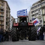 
              A farmer sits on a tractor with a Greek flag during a protest outside of the Agriculture Ministry in Athens, Greece, on Friday, March 18, 2022. Greek farmers are protesting higher production costs, pressing the center-right government to reduce electricity bills and fuel tax and increase subsidies for animal farms. They gathered outside the ministry of agriculture and were planning to march from there to parliament in central Athens. (AP Photo/Thanassis Stavrakis)
            