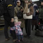 
              A child clutches a man's leg before boarding a Lviv bound train, in Kyiv, Ukraine, Thursday, March 3, 2022. Ukrainian President Volodymyr Zelenskyy's office says a second round of talks with Russia aimed at stopping the fighting that has sent more than 1 million people fleeing over Ukraine's borders, has begun in neighboring Belarus, but the two sides appeared to have little common ground. (AP Photo/Vadim Ghirda)
            