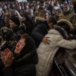 
              Relatives and friends attend a funeral ceremony for four of the Ukrainian military servicemen, who were killed during an airstrike in a military base in Yarokiv, in a church in Lviv, Ukraine, Tuesday, March 15, 2022. At least 35 people were killed and many wounded in Sunday's Russian missile strike on a military training base near Ukraine's western border with NATO member Poland. (AP Photo/Bernat Armangue)
            