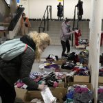 
              Refugees from Ukraine look for clothes at a sports hall turned refugee center in Warsaw, Poland, Friday, March 18, 2022. (AP Photo/Czarek Sokolowski)
            