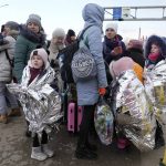 
              Refugees stand in a group after fleeing the war from neighbouring Ukraine at the border crossing in Palanca, Moldova, Thursday, March 10, 2022. (AP Photo/Sergei Grits)
            