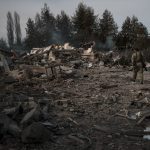 
              A volunteer of the Ukrainian Territorial Defense Forces walks on the debris of a car wash destroyed by a Russian bombing in Baryshivka, east of Kyiv, Ukraine, Friday, March 11, 2022. (AP Photo/Felipe Dana)
            