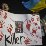 
              Women hold a placard against Russian President Vladimir Putin as they attend a pro-Ukraine protest against Russia's invasion of Ukraine in Tel Aviv, Israel, Thursday, March 3, 2022. (AP Photo/Ariel Schalit)
            