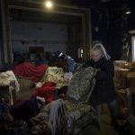 
              A volunteer folds army clothes inside a Ukrainian volunteer center in Mykolaiv, southern Ukraine, on Monday, March 28, 2022. Ukrainian volunteers have set up a center to supply army and civilians with clothes, food , medicines, and makeshift bullet proof vests. (AP Photo/Petros Giannakouris)
            