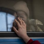 
              Displaced Ukrainians on a Poland-bound train bid farewell in Lviv, western Ukraine, Tuesday, March 22, 2022. The U.N. refugee agency says more than 3.5 million people have fled Ukraine since Russia's invasion, passing another milestone in an exodus that has led to Europe's worst refugee crisis since World War II. (AP Photo/Bernat Armangue)
            