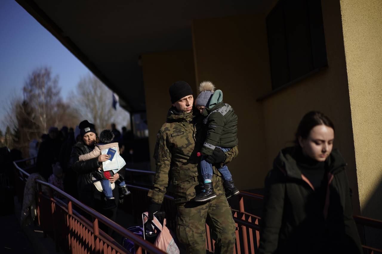 A Polish soldier holds a child as Ukrainian refugees arrive from Lviv to Przemysl train station, so...