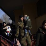 
              A Polish soldier holds a child as Ukrainian refugees arrive from Lviv to Przemysl train station, southeastern Poland, on Friday, March 11, 2022. Thousands of people have been killed and more than 2.3 million have fled the country since Russian troops crossed into Ukraine on Feb. 24. (AP Photo/Daniel Cole)
            