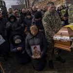 
              Relatives and friends mourn the body of senior police sergeant Roman Rushchyshyn in the village of Soposhyn, outskirts of Lviv, western Ukraine, Thursday, March 10, 2022, in Lviv. Rushchyshyn, a member of the Lviv Special Police Patrol Battalion, was killed in the Luhansk Region. Temporary cease-fires to allow evacuations and humanitarian aid have repeatedly faltered, with Ukraine accusing Russia of continuing its bombardments. (AP Photo/Bernat Armangue)
            