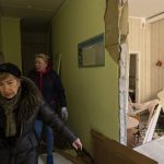 
              Women walks inside a school damaged among other residential buildings following a bombing in Kyiv, Ukraine, Friday, March 18, 2022. Russian forces pressed their assault on Ukrainian cities Friday, with new missile strikes and shelling on the edges of the capital Kyiv and the western city of Lviv, as world leaders pushed for an investigation of the Kremlin's repeated attacks on civilian targets, including schools, hospitals and residential areas. (AP Photo/Rodrigo Abd)
            