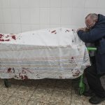 
              Serhii, father of teenager Iliya, cries on his son's lifeless body lying on a stretcher at a maternity hospital converted into a medical ward in Mariupol, Ukraine, Wednesday, March 2, 2022. (AP Photo/Evgeniy Maloletka)
            