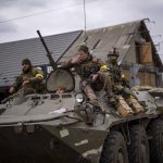 
              Ukrainian soldiers drive on an armored military vehicle in the outskirts of Kyiv, Ukraine, Saturday, March 5, 2022. (AP Photo/Emilio Morenatti)
            
