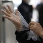 
              A voter wears plastic gloves to help protect against the spread of the coronavirus upon arrival to cast his ballot for the presidential election at a local polling station in Seoul, South Korea, Wednesday, March 9, 2022. South Koreans were voting for a new president Wednesday, with a liberal ruling party candidate considered a maverick and a conservative former prosecutor considered the favorites in a tight race that has aggravated the country's domestic divisions. (AP Photo/Lee Jin-man)
            