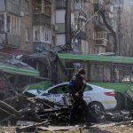 
              A Ukrainian soldier passes by a destroyed a trolleybus and taxi after a Russian bombing attack in Kyiv, Ukraine, Monday, March 14, 2022. (AP Photo/Efrem Lukatsky)
            