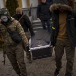 
              Militia men carry the coffin with the body of Volodymyr Nezhenets, 54, during his funeral in the city of Kyiv, Ukraine, Friday, March 4, 2022. A small group of reservists are burying their comrade, 54-year-old Volodymyr Nezhenets, who was one of three killed on Feb. 26 in an ambush Ukrainian authorities say was caused by Russian 'saboteurs'. (AP Photo/Emilio Morenatti)
            