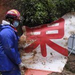 
              In this photo released by Xinhua News Agency, a rescue team member carries a piece of debris at the China Eastern flight crash site in Tengxian County in southern China's Guangxi Zhuang Autonomous Region on Thursday, March 24, 2022. Hundreds of people in rain gear and rubber boots searched muddy, forested hills in southern China on Thursday for the second flight recorder from a jetliner that crashed with 132 people aboard. (Lu Boan/Xinhua via AP)
            