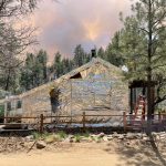 Crews protect the Palace Station Historic Stagecoach Stop Cabin from the Crooks Fire with a foil-like wrap. (U.S. Forest Service - Prescott National Forest/Crooks Fire Public Information Officer Sergio Montañez)