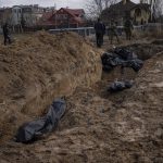 
              Journalists stand by a mass grave in Bucha, on the outskirts of Kyiv, Ukraine, Monday, April 4, 2022. Russia is facing a fresh wave of condemnation after evidence emerged of what appeared to be deliberate killings of civilians in Ukraine. (AP Photo/Rodrigo Abd)
            