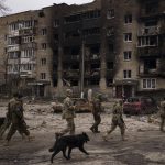 
              Ukrainian soldiers walk next to heavily damaged residential buildings in Irpin, on the outskirts of Kyiv, Ukraine, Wednesday, April 6, 2022. (AP Photo/Felipe Dana)
            