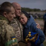 
              Irina Tromsa, 55, is contorted by comrades of her son Bogdan, 24, a Ukrainian paratrooper from the 95th Brigade killed during fighting against Russian troops in the north-east of the country, during his funeral at the cemetery in Bucha, in the outskirts of Kyiv, on Saturday, April 23, 2022. (AP Photo/Emilio Morenatti)
            