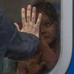 
              A girl inside a train reacts as she says goodbye to relatives at the train station in Odesa, before she and members of her family escape the war in Ukraine to Poland, on Saturday, April 2, 2022. (AP Photo/Petros Giannakouris)
            