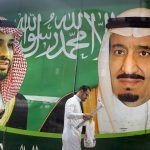 
              FILE - People walk past a banner showing Saudi King Salman, right, and his Crown Prince Mohammed bin Salman, outside a mall in Jiddah, Saudi Arabia, Saturday, March 7, 2020. A spike in global energy prices caused by Russia's war on Ukraine benefits Saudi Arabia as the world's top oil exporter, but problems remain for the kingdom's impulsive crown prince. (AP Photo/Amr Nabil, File)
            