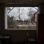 
              Firefighters are seen through the destroyed window of an apartment as they work to extinguish a fire after a Russian attack in Kharkiv, Ukraine, Tuesday, April 12, 2022. (AP Photo/Felipe Dana)
            