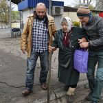 
              Men help Maria Dyachenko, 83, to board a transport during evacuation of civilians in Kramatorsk, Ukraine, Tuesday, April 12, 2022. Maria left the village of Dovhenke, about 25 km south of Izyum, Kharkiv region. She told her village was completely destroyed during fightings between Russian and Ukrainian forces, only few houses are intact there. Maria came to Kramatorsk to get chance for evacuation and asked volunteers to move her to Ukrainian city of Dnipro. (AP Photo/Andriy Andriyenko)
            