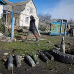 
              A boy walks by unexploded Russian shells in the village of Andriyivka close to Kyiv, Ukraine, Monday, April 11, 2022. Andriyivka was occupied by the Russian troops at the beginning of the Russia-Ukraine war and freed recently by the Ukrainian army. (AP Photo/Efrem Lukatsky)
            