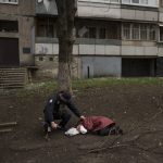 
              A police officer checks the body of a woman killed during a Russian bombardment at a residential neighborhood in Kharkiv, Ukraine, Tuesday, April 19, 2022. Russia ratcheted up its battle for control of Ukraine’s eastern industrial heartland on Tuesday, intensifying assaults on cities and towns along a front hundreds of miles long in what officials on both sides described as a new phase of the war. (AP Photo/Felipe Dana)
            