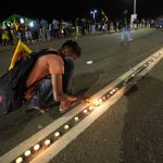 Sri Lankans light candles during a vigil condemning police shooting at protesters in Rambukkana, 90 kilometers (55 miles) northeast of Colombo, at a protest outside the president's office in Colombo, Sri Lanka, Tuesday, April 19, 2022. Sri Lankan police opened fire Tuesday at a group of people protesting new fuel price increases, killing one and injuring 10 others, in the first shooting by security forces during weeks of demonstrations over the country's worst economic crisis in decades. (AP Photo/Eranga Jayawardena)