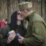 
              A military couple share a tender moment after an Easter cakes blessing ceremony on Easter eve at a military position outside Kyiv, Ukraine, Saturday, Apr. 23, 2022. (AP Photo/Efrem Lukatsky)
            