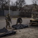 
              Ukrainian soldiers recover the remains of four killed civilians from inside a charred vehicle in Bucha, outskirts of Kyiv, Ukraine, Tuesday, April 5, 2022. Ukraine’s president plans to address the U.N.’s most powerful body after even more grisly evidence emerged of civilian massacres in areas that Russian forces recently left. (AP Photo/Felipe Dana)
            