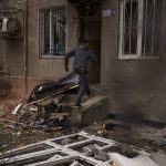 
              A man walks into his burning building after a Russian bombardment in Kharkiv, Ukraine, Sunday, April 17, 2022. (AP Photo/Felipe Dana)
            