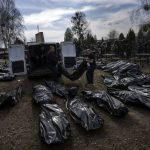 
              Cemetery workers unload bodies of killed civilians from a van in the cemetery in Bucha, outskirts of Kyiv, Ukraine, Thursday, April 7, 2022. (AP Photo/Rodrigo Abd)
            