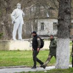 
              People pass a monument to Soviet Union founder Vladimir Lenin in Chernobyl, Ukraine, Saturday, April 16, 2022. Thousands of tanks and troops rumbled into the forested exclusion zone around the shuttered Chernobyl nuclear power plant in the earliest hours of Russia’s invasion of Ukraine in February, churning up highly contaminated soil from the site of the 1986 accident that was the world's worst nuclear disaster. (AP Photo/Efrem Lukatsky)
            