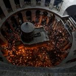 
              Christian pilgrims hold candles as they gather during the ceremony of the Holy Fire at Church of the Holy Sepulchre, where many Christians believe Jesus was crucified, buried and rose from the dead, in the Old City of Jerusalem dead, Saturday, April 23, 2022. (AP Photo/Tsafrir Abayov)
            