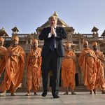 
              Britain's Prime Minister Boris Johnson, center, poses with Sadhus, or Hindu holy men, in front of the Swaminarayan Akshardham temple, in Gandhinagar, part of his two-day trip to India, Thursday, April 21, 2022. (Ben Stansall/Pool Photo via AP)
            