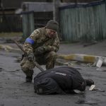 
              A Ukrainian serviceman checks the dead body of a civilian for booby traps in the formerly Russian-occupied Kyiv suburb of Bucha, Ukraine, Saturday, April 2, 2022. As Russian forces pull back from Ukraine's capital region, retreating troops are creating a "catastrophic" situation for civilians by leaving mines around homes, abandoned equipment and "even the bodies of those killed," President Volodymyr Zelenskyy warned Saturday.(AP Photo/Vadim Ghirda)
            