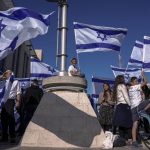 
              Israeli right wing activists with Israeli flags gather for a march  in Jerusalem, Wednesday, April 20, 2022. A group of Israeli ultra-nationalists said it is determined to go ahead with a flag-waving march around predominantly Palestinian areas of Jerusalem's Old City, brushing aside a police ban of an event that served as one of the triggers of last year's Israel-Gaza war. (AP Photo/Ariel Schalit)
            