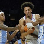 
              Kansas forward Jalen Wilson, center, vies for the ball with North Carolina forward Armando Bacot, left, and guard Leaky Black during the first half of a college basketball game in the finals of the Men's Final Four NCAA tournament, Monday, April 4, 2022, in New Orleans. (AP Photo/David J. Phillip)
            