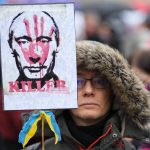 
              A demonstrator holds a placard of Russian President Vladimir Putin covered with a blood-smeared hand and a ribbon in the colors of the Ukraine flag during a rally in Budapest, Hungary, Saturday, April 2, 2022, ahead of Sunday's election. (AP Photo/Petr David Josek)
            