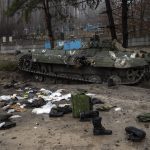 
              Military gear left behind by Russian soldiers lay scattered near a tank during a military sweep by Ukrainian soldiers after the Russians' withdrawal from the area on the outskirts of Kyiv, Ukraine, Friday, April 1, 2022. (AP Photo/Rodrigo Abd)
            