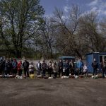 
              Orthodox believers wait for blessing in a yard of the All Saints church during the Easter celebration in Bahmut, eastern Ukraine, Sunday, April 24, 2022. (AP Photo/Evgeniy Maloletka)
            