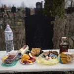 
              A table with food as a part of a Ukrainian tradition ready to be eaten near the grave of Oleksandr, 32, on the day after his funeral at Bucha cemetery, on the outskirts of Kyiv, Ukraine on Saturday, April 16, 2022. Oleksandr, who joined the territorial Ukrainian defence as a co-ordinator was killed by a gunshot by the Russian Army. (AP Photo/Rodrigo Abd)
            