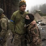 
              Ukrainian army soldiers, Igor, 23, embraces his wife Dasha, 22, after a military sweep to search for possible remnants of Russian troops after their withdrawal from villages in the outskirts of Kyiv, Ukraine, Friday, April 1, 2022. (AP Photo/Rodrigo Abd)
            