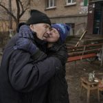 
              A woman kisses a man while cooking on an open fire outside an apartment building which had no electricity, water or gas since the beginning of the Russian invasion in Bucha, Ukraine, Sunday, April 3, 2022. Associated Press journalists in Bucha, a small city northwest of Kyiv, saw the bodies of at least nine people in civilian clothes who appeared to have been killed at close range. At least two had their hands tied behind their backs.(AP Photo/Vadim Ghirda)
            