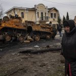 
              A woman walks next to a destroyed Russian armor vehicle in Bucha, in the outskirts of Kyiv, Ukraine, Tuesday, April 5, 2022. Ukraine’s president plans to address the U.N.’s most powerful body after even more grisly evidence emerged of civilian massacres in areas that Russian forces recently left. (AP Photo/Rodrigo Abd)
            